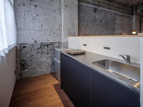 a kitchen with a sink and a counter top at Arcade Hotel in Fuji