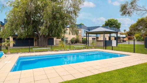 a swimming pool in a yard next to a house at El Penguini in Cowes