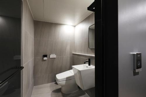 a bathroom with a white toilet and a sink at Hotel The One in Gangneung