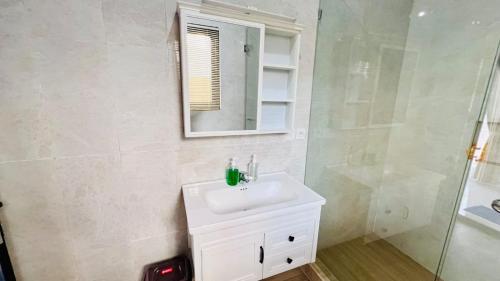 a bathroom with a sink and a mirror and a shower at Ucu House in Jimbaran