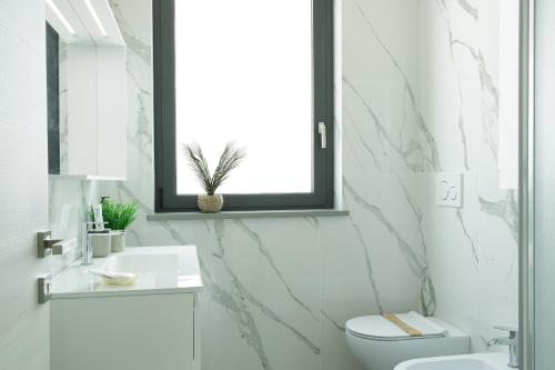 a white bathroom with a toilet and a sink at Casale Auriga - Oltrepo' Pavese in Codevilla
