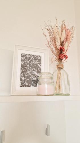 a vase with flowers in it sitting on a shelf at Apartments nahe der Südsteirischen Weinstraße in Straß in Steiermark