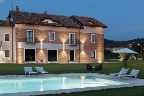 a villa with a swimming pool in front of a building at Casale Auriga - Oltrepo' Pavese in Codevilla