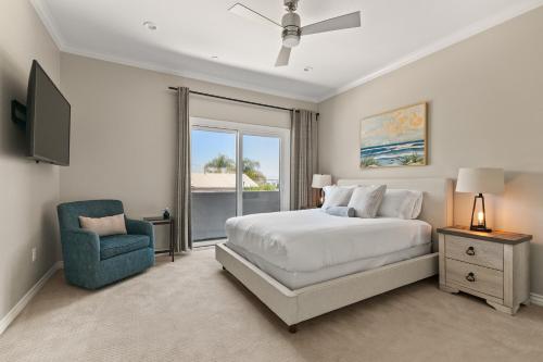 a bedroom with a bed and a chair and a window at Carlsbad Village Escape 3-Bed 2,5-Bath steps from the beach in Carlsbad