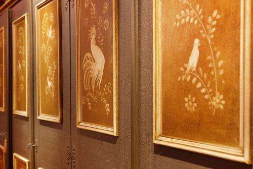 a row of paintings of birds on a wall at Ferienunterkünfe Beim Posthalter in Oberammergau
