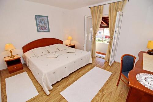 a bedroom with a large white bed in a room at Apartment with terrace and garden in Vela Luka