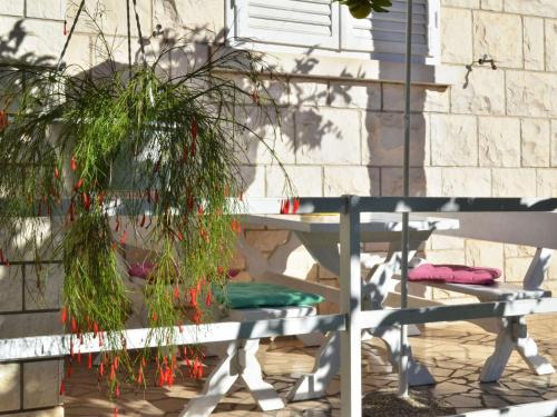 a bench with a plant next to a building at LaidBack Apartments - Standard One Bedroom Apartment with Balcony and Sea View Azur in Orebić