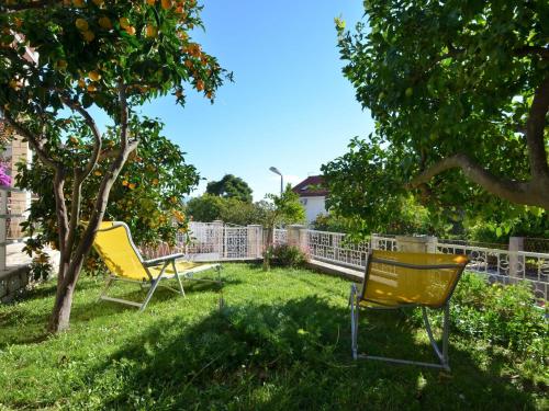 two yellow chairs sitting in the grass in a yard at LaidBack Apartments - Standard One Bedroom Apartment with Balcony and Sea View Azur in Orebić