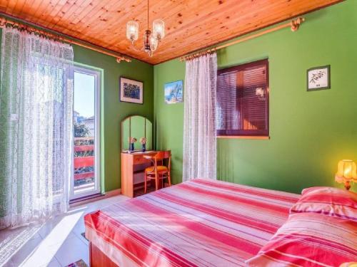 a bedroom with green walls and a bed and a desk at Apartment Blamax with Terrace and Sea View in Mali Lošinj