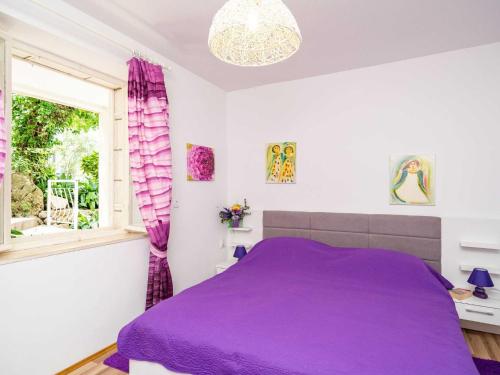 - un lit violet dans une chambre blanche dotée d'une fenêtre dans l'établissement Apartments & Rooms Mara & Petrunjela - Two Bedroom Apartment with Terrace and Sea View, à Cavtat