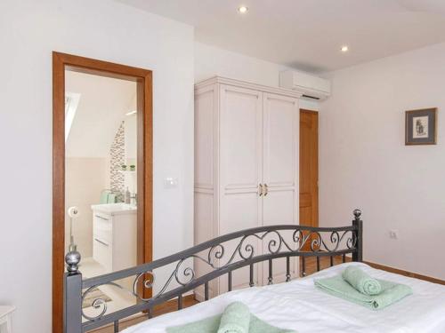 a bedroom with a bed and a mirror at Holiday Home Lovi te-Three Bedroom Holiday Home with Pool and Sea View in Lovište