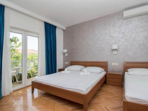 une chambre avec deux lits et une grande fenêtre dans l'établissement Apartments Antonio - Studio with Balcony 2, à Tučepi