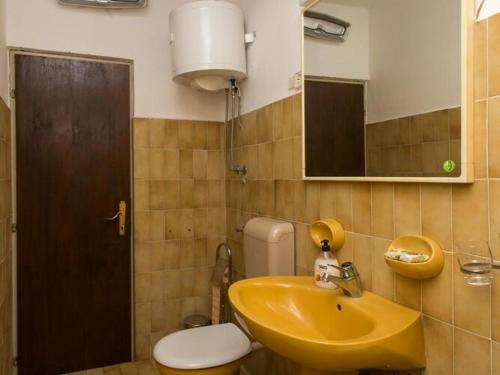 a bathroom with a yellow sink and a toilet at Apartments Maria Kolo ep- Three Bedroom Apartment with Backyard Terrace and Sea View in Koločep