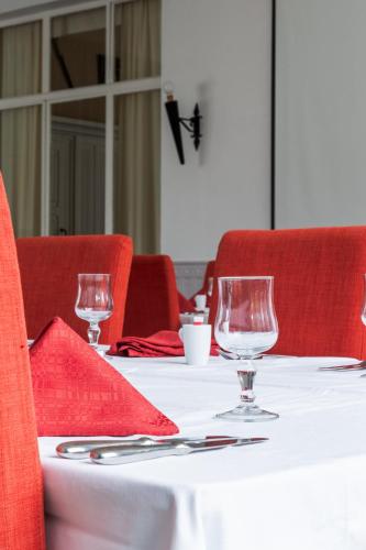a table with two empty wine glasses on it at Hôtel Restaurant Du Château in Josselin