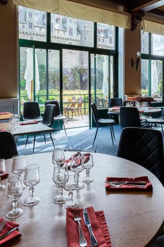 a table with wine glasses on top of it at Hôtel Restaurant Du Château in Josselin