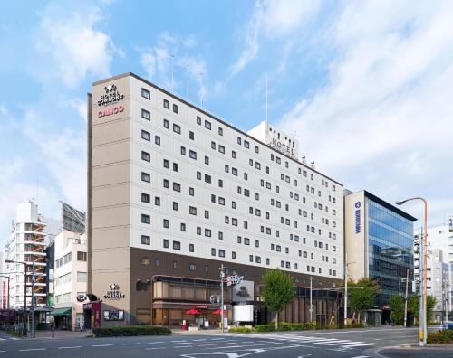 a large white building on a city street at Hotel Consort Shin-Osaka in Osaka