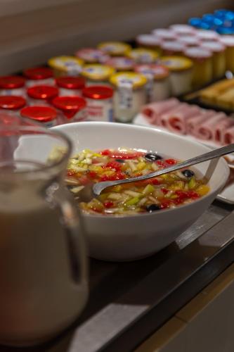 a bowl of food with tongs in it on a counter at Hôtel Restaurant Du Château in Josselin