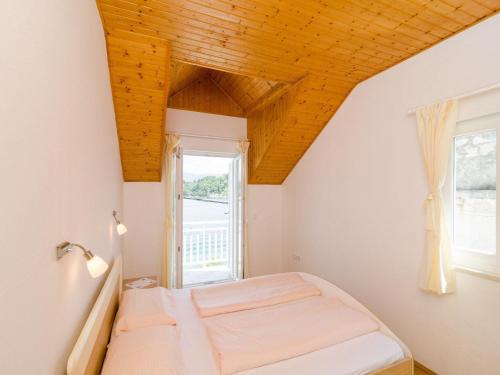 ein Schlafzimmer mit einem Bett und einem Fenster in der Unterkunft Holiday Home Ma us-One Bedroom Apartment with Balcony in Koločep