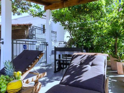 a patio with a table and a bench and fruit at Apartments Ammos - One Bedroom Apartment with Shared Terrace and Sea View Veliki in Saplunara