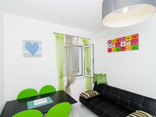 a living room with a black couch and a table at Apartments Ammos - One Bedroom Apartment with Shared Terrace and Sea View Veliki in Saplunara