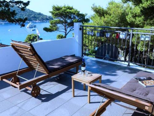 a patio with a chair and a table and water at Apartments Ammos - One Bedroom Apartment with Shared Terrace and Sea View Veliki in Saplunara