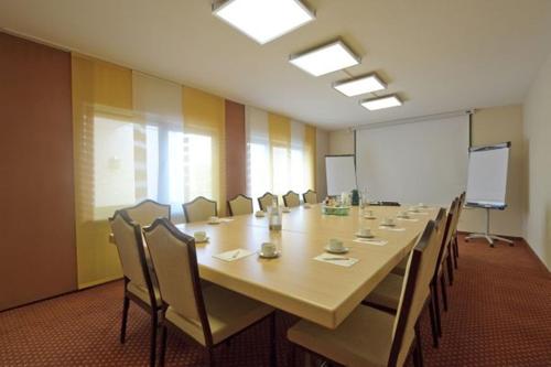 una gran sala de conferencias con una mesa larga y sillas en Hotel Café Nothnagel, en Griesheim