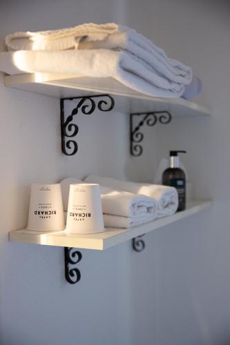a shelf with towels and candles on it at Hôtel Restaurant Du Château in Josselin