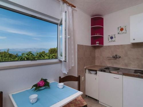 cocina con mesa y ventana grande en Holiday Home Blossom - Four Bedroom Holiday Home with Outdoor Pool and Jacuzzi - ST, en Supetar