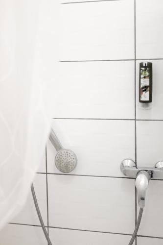 a shower with a faucet in a white bathroom at Hôtel Restaurant Du Château in Josselin