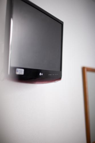 a flat screen tv hanging on a wall at Hôtel Restaurant Du Château in Josselin