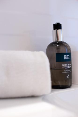 a bottle of essential oil next to a roll of toilet paper at Hôtel Restaurant Du Château in Josselin