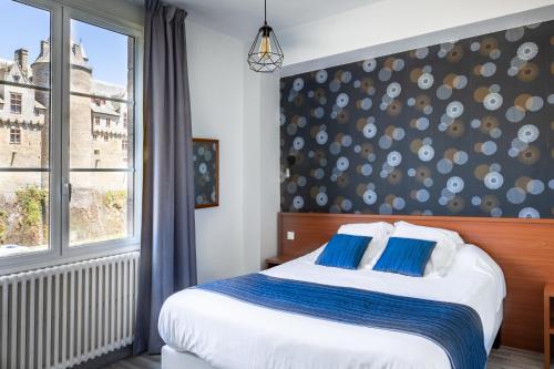 a bedroom with a large bed and a window at Hôtel Restaurant Du Château in Josselin