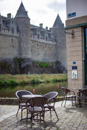 a group of chairs and tables in front of a castle at Hôtel Restaurant Du Château in Josselin