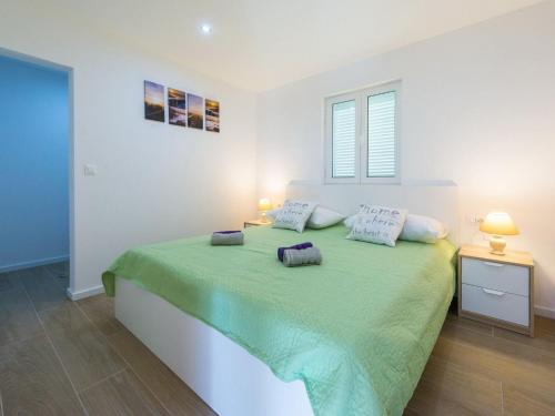 ein Schlafzimmer mit einem grünen Bett mit zwei Kissen darauf in der Unterkunft Villa Dundo Pero - Four Bedroom Villa with Swimming Pool and Sea View in Babino Polje