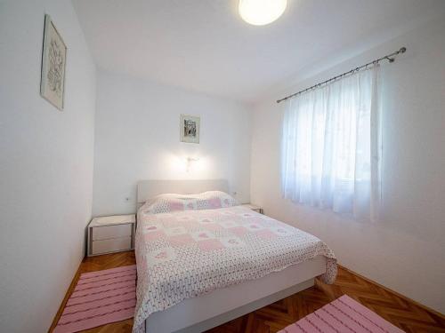 a small bedroom with a bed and a window at Apartments Magdalena - Standard Apartment with Terrace and Sea View A2 in Bol