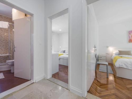 a white room with two beds and a bathroom at Apartments Ema-Two Bedroom Apartment with Sea View Perla in Rogotin