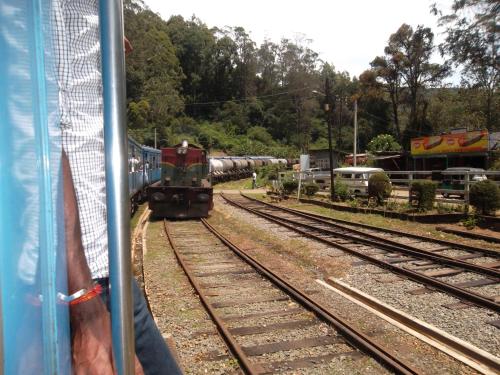 a train traveling down the tracks with a train at Panorama Accommodations Nuwara Eliya in Nuwara Eliya