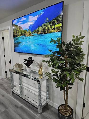 a living room with a tv and a potted plant at Comfort Guest Suite NE Calgary - Near Airport in Calgary