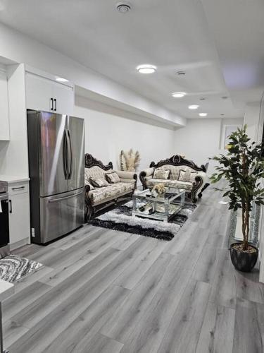 a living room with a stainless steel refrigerator at Comfort Guest Suite NE Calgary - Near Airport in Calgary