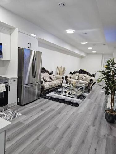 a living room with a stainless steel refrigerator at Comfort Guest Suite NE Calgary - Near Airport in Calgary