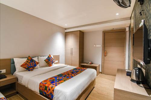 a bedroom with a large bed and a television at FabHotel Sivalika Inn - Howrah in Kolkata
