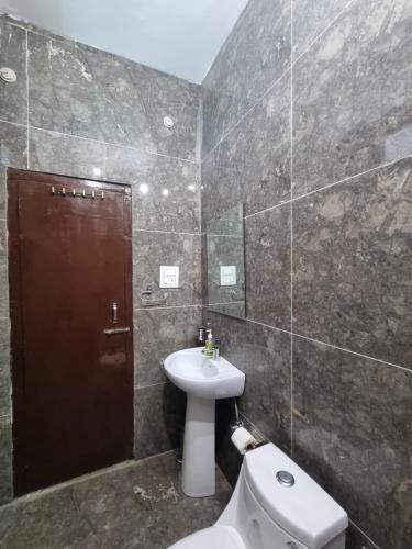 a bathroom with a toilet and a sink at Baikunth Homes in Dalhousie