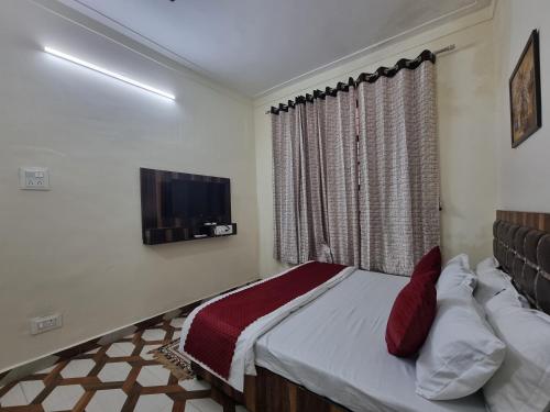 a bedroom with a bed and a tv on the wall at Baikunth Homes in Dalhousie
