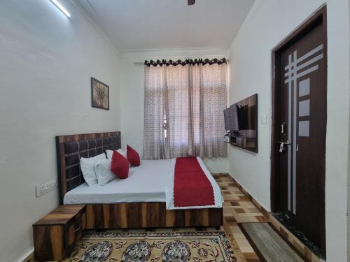 a bedroom with a bed with red pillows and a window at Baikunth Homes in Dalhousie