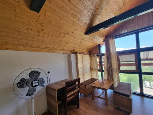 a dining room with a table and a fan at Baikunth Homes in Dalhousie