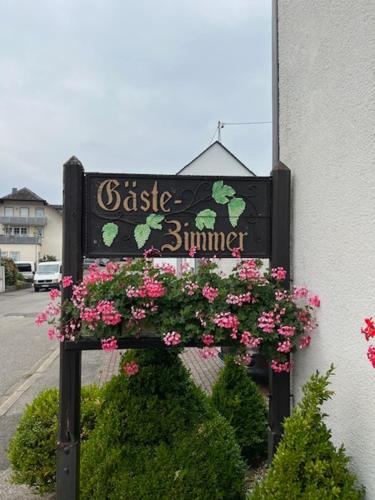 a sign for a restaurant with pink flowers on it at Gästehaus Elisabeth Bach in Mehring