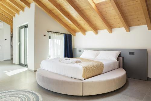 a bedroom with a large white bed and a large ottoman at Casale Auriga - Oltrepo' Pavese in Codevilla