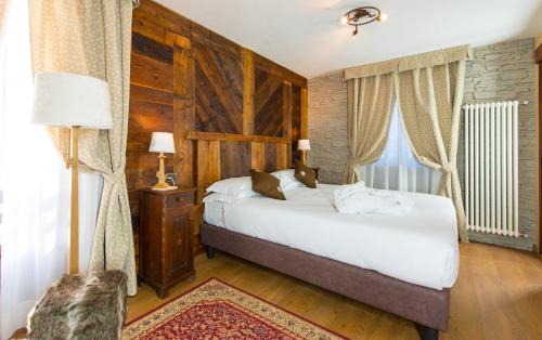 sypialnia z dużym białym łóżkiem i oknem w obiekcie Hotel Edelweiss 3 Stelle SUPERIOR w mieście Breuil-Cervinia