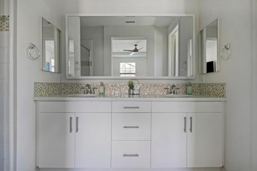 a white bathroom with two sinks and a large mirror at Fun In The Sun 2 Bed 2 Bath Home in Oceanside