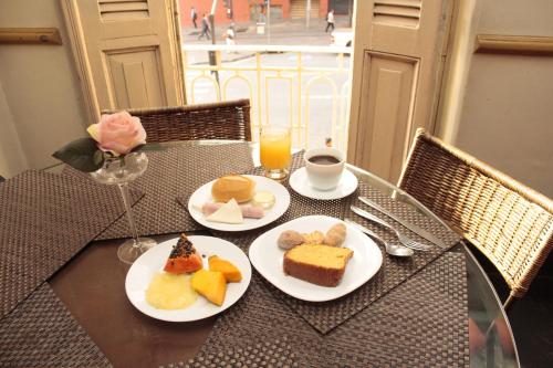 a table with two plates of food and a cup of coffee at Sul América Palace Hotel in Belo Horizonte